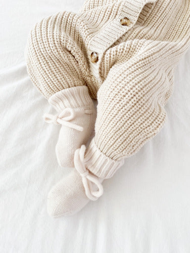 Baby mit Babysocken Merinowolle creme 